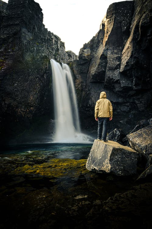 Strong waterfall with a yellow jacket man